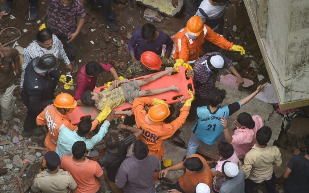 Thane: National Disaster Response Force (NDRF) and Fire brigade rescue an injured child after a three storey building collapsed, at Bhiwandi in Thane district, Monday, Sept. 21, 2020. (PTI Photo/Mitesh Bhuvad)